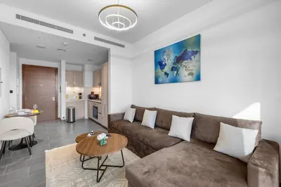 a living room with a couch and a table at Stylish 1BR Retreat in Sobha Crest with Balcony in Dubai