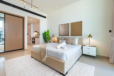 a bedroom with a large white bed and a sliding glass door at Near Gadaf Community Park, Few Minutes Walk to Circle Mall, Short Drive to Dubai Miracle Garden and Butterfly Garden - Binghatti Amber, JVC by Deluxe Holiday Homes in Dubai