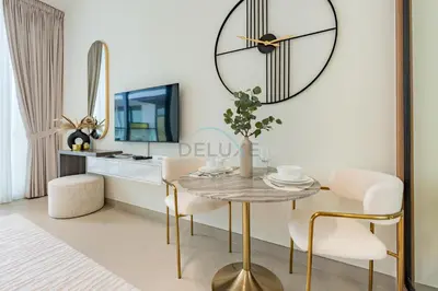a dining room with a table and a clock on the wall at Near Gadaf Community Park, Few Minutes Walk to Circle Mall, Short Drive to Dubai Miracle Garden and Butterfly Garden - Binghatti Amber, JVC by Deluxe Holiday Homes in Dubai