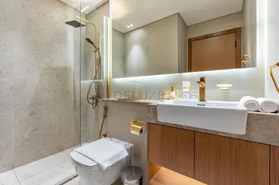 a bathroom with a sink and a toilet and a mirror at Near Gadaf Community Park, Few Minutes Walk to Circle Mall, Short Drive to Dubai Miracle Garden and Butterfly Garden - Binghatti Amber, JVC by Deluxe Holiday Homes in Dubai