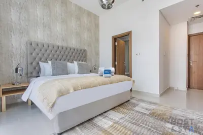 a bedroom with a large bed with a large headboard at Parkview 2BR in Orchid, Damac Hills in Dubai