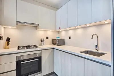a kitchen with white cabinets and a sink at STAY BY LATINEM Luxury 2BR Holiday Home CC 911 Near Burj Khalifa in Dubai