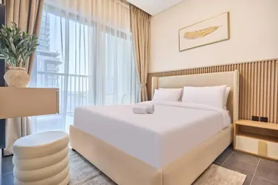 a bedroom with a large white bed and a window at STAY BY LATINEM Luxury 2BR Holiday Home CC 911 Near Burj Khalifa in Dubai