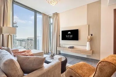 a living room with a couch and a tv at STAY BY LATINEM Luxury 2BR Holiday Home CC 911 Near Burj Khalifa in Dubai
