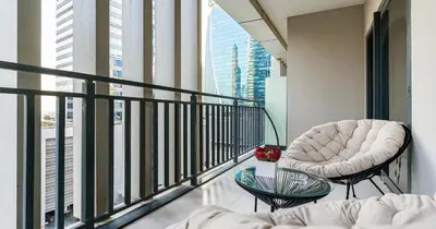 a room with a balcony with a chair and a table at Savis Homes - Stylish 1 BR near Metro Station in Business Bay in Dubai