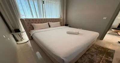 a bedroom with a large white bed with a pillow on it at Savis Homes - Stylish 1 BR near Metro Station in Business Bay in Dubai
