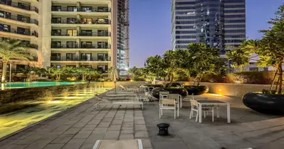 a hotel patio with tables and chairs and buildings at Savis Homes - Stylish 1 BR near Metro Station in Business Bay in Dubai