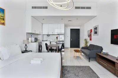 a bedroom with a large bed and a living room at Modern Studio with City Views Near Miracle Garden in Dubai