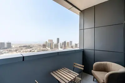 a chair and a chair in a room with a window at Modern Studio with City Views Near Miracle Garden in Dubai