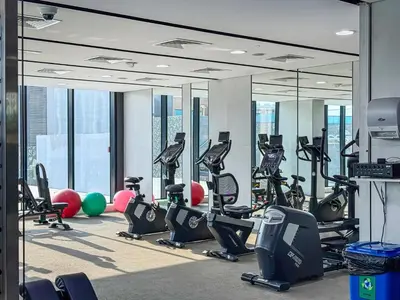 a gym with treadmills and exercise equipment in a building at Modern Studio with City Views Near Miracle Garden in Dubai