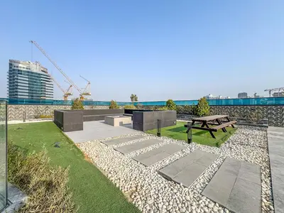 a park with a bench and a picnic table at Modern Studio with City Views Near Miracle Garden in Dubai