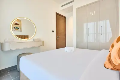a white bedroom with a white bed and a mirror at STAY BY LATINEM Luxury 1BR Holiday Home CB 3113 Near Burj Khalifa in Dubai