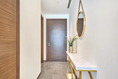 a hallway with a wooden door and a bench and a mirror at STAY BY LATINEM Luxury 1BR Holiday Home CB 3113 Near Burj Khalifa in Dubai