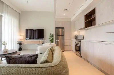 a living room with a couch and a kitchen at Two Bedroom Apartment Down Town in Dubai
