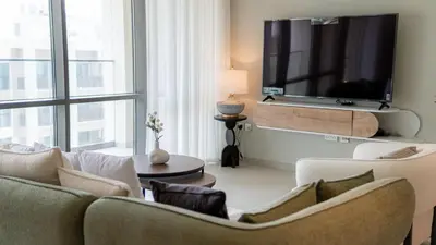 a living room with two couches and a flat screen tv at Two Bedroom Apartment Down Town in Dubai