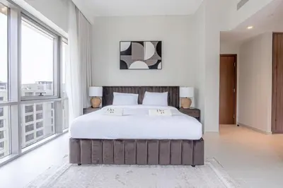 a bedroom with a large bed and large windows at Two Bedroom Apartment Down Town in Dubai