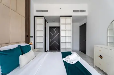 a bedroom with a large white bed with towels on it at GuestReady - 1 BHK | 5min to Butterfly Garden in Dubai