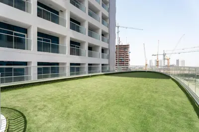 a large green lawn on the roof of a building at GuestReady - 1 BHK | 5min to Butterfly Garden in Dubai
