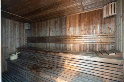 an empty wooden sauna with a bucket in it at GuestReady - 1 BHK | 5min to Butterfly Garden in Dubai