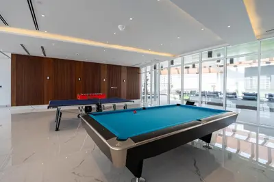 two pool tables in a room with glass windows at GuestReady - 1 BHK | 5min to Butterfly Garden in Dubai
