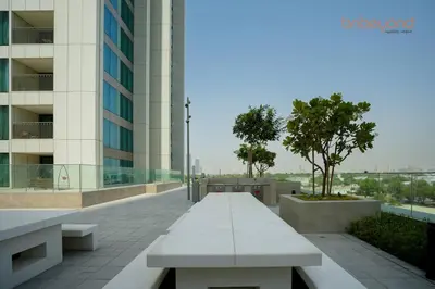 a bench in front of a building with a tree at Bnbeyond Skyline Luxury in Dubai