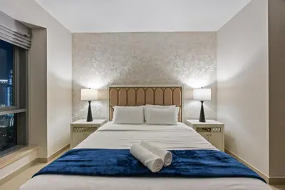 a bedroom with a large bed with two lamps at Breathtaking Burj Khalifa & Fountain Views! in Dubai