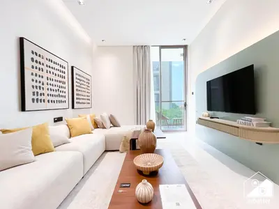 a living room with a white couch and a tv at Exclusive 1BR, Modern Comfort & Prime Location in Dubai