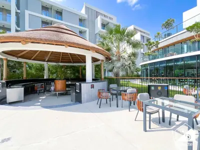 a patio with tables and chairs in front of a building at Exclusive 1BR, Modern Comfort & Prime Location in Dubai