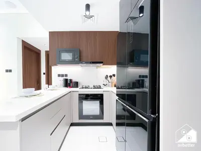 a kitchen with white counters and a stove top oven at Exclusive 1BR, Modern Comfort & Prime Location in Dubai