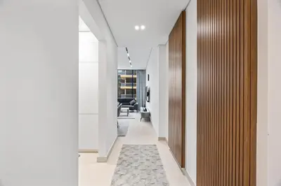a hallway with white walls and a carpet at Trillionaire Residences By Binghatti - Classy 2BR in Dubai