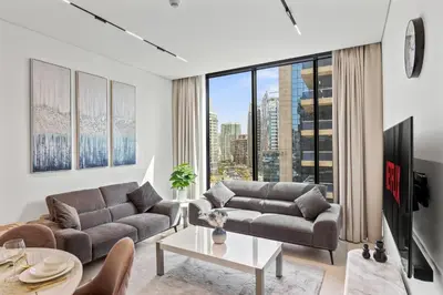 a living room with two couches and a large window at Trillionaire Residences By Binghatti - Classy 2BR in Dubai