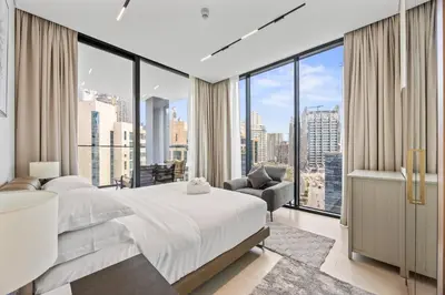 a bedroom with a large bed and large windows at Trillionaire Residences By Binghatti - Classy 2BR in Dubai