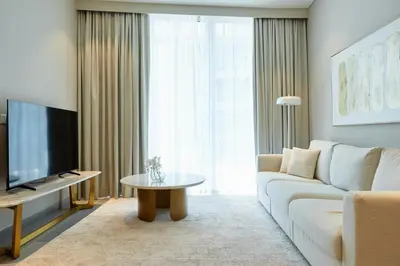 a living room with a white couch and a tv at Star of Dubai Marina 2 Br 5 Guests in Dubai