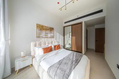 a bedroom with a large white bed with orange pillows at Private Pool I Sleeps 6 I Circle Mall in Dubai