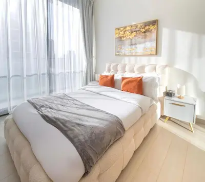 a bedroom with a large white bed with orange pillows at Private Pool I Sleeps 6 I Circle Mall in Dubai