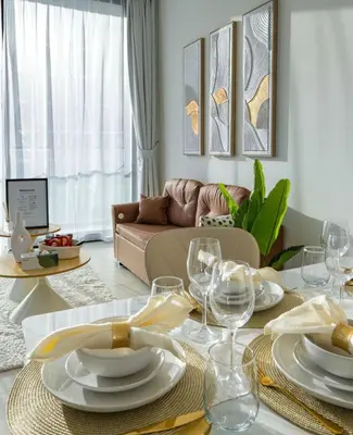 a living room with a table with plates and wine glasses at Private Pool I Sleeps 6 I Circle Mall in Dubai