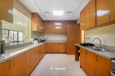 a large kitchen with wooden cabinets and a sink at 4BR Villa in Prime Location with Private Garden in Dubai