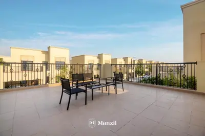 a balcony with a table and chairs on it at 4BR Villa in Prime Location with Private Garden in Dubai