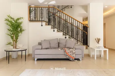 a living room with a couch and a staircase at 4BR Villa in Prime Location with Private Garden in Dubai
