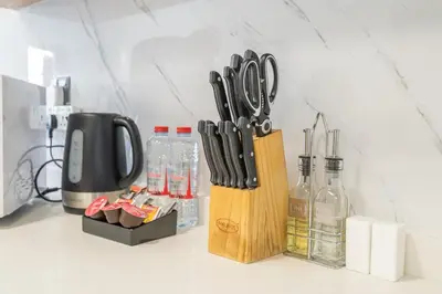 a kitchen counter with a knife block and bottles of wine at Modern 1BHK Apartment in Pantheon JVC by Czechin in Dubai