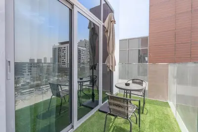 a balcony with a table and chairs on a building at Modern 1BHK Apartment in Pantheon JVC by Czechin in Dubai