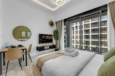 a bedroom with a bed and a desk and a large window at Elegant Studio Retreat in the Heart of Dubai in Dubai