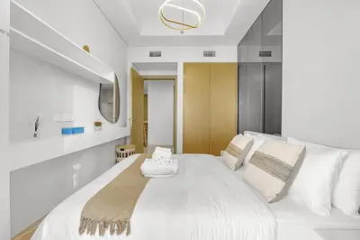 a white bedroom with a large white bed and a sink at Elegant 1 Bedroom Retreat in Business Bay in Dubai