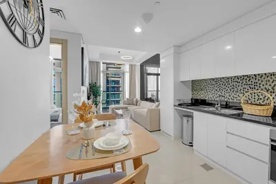 a kitchen and living room with a wooden table and chairs at Elegant 1 Bedroom Retreat in Business Bay in Dubai