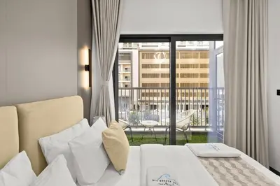 a bedroom with a bed and a view of a balcony at Elegant 1BR with Bedroom Balcony - Sobha Crest C in Dubai