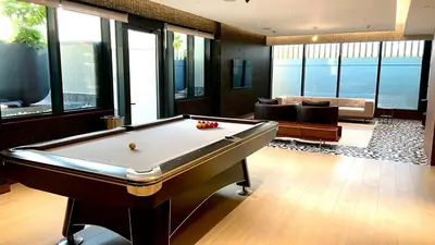 a billiard room with a pool table and a couch at Elegant 1BR with Bedroom Balcony - Sobha Crest C in Dubai