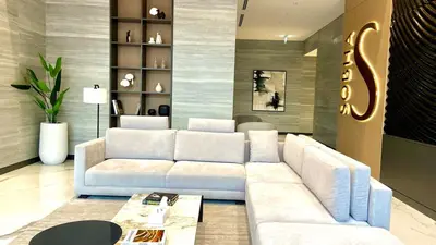 a living room with a white couch and a table at Elegant 1BR with Bedroom Balcony - Sobha Crest C in Dubai