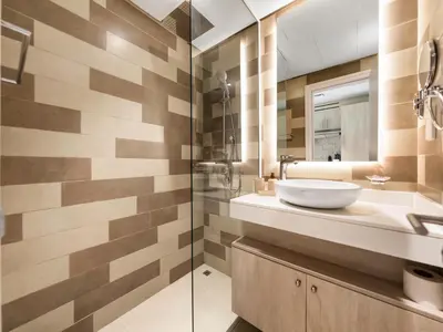 a bathroom with a sink and a glass shower at Wonderful Stay at 7 Palm - Rooftop Infinity Pool - Direct Beach Access - Brand New Luxury Apartments in Dubai