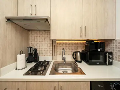 a kitchen with a sink and a microwave at Wonderful Stay at 7 Palm - Rooftop Infinity Pool - Direct Beach Access - Brand New Luxury Apartments in Dubai