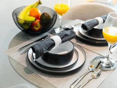 a table with plates and utensils and a bowl of fruit at Wonderful Stay at 7 Palm - Rooftop Infinity Pool - Direct Beach Access - Brand New Luxury Apartments in Dubai